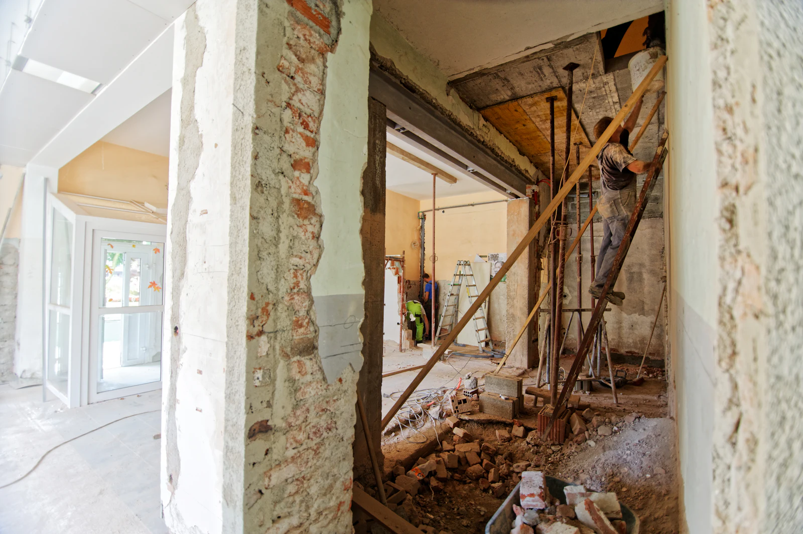 Artisan sur un escabeau dans une pièce en cours de rénovation