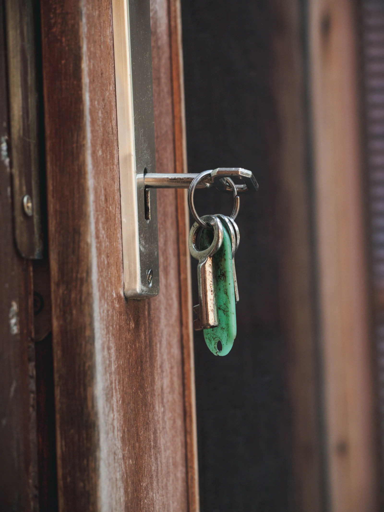 Trousseau de clés engagé dans la serrure d'une porte en bois