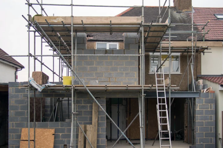 Extension en parpaings et briques en cours de construction à l'arrière d'une maison