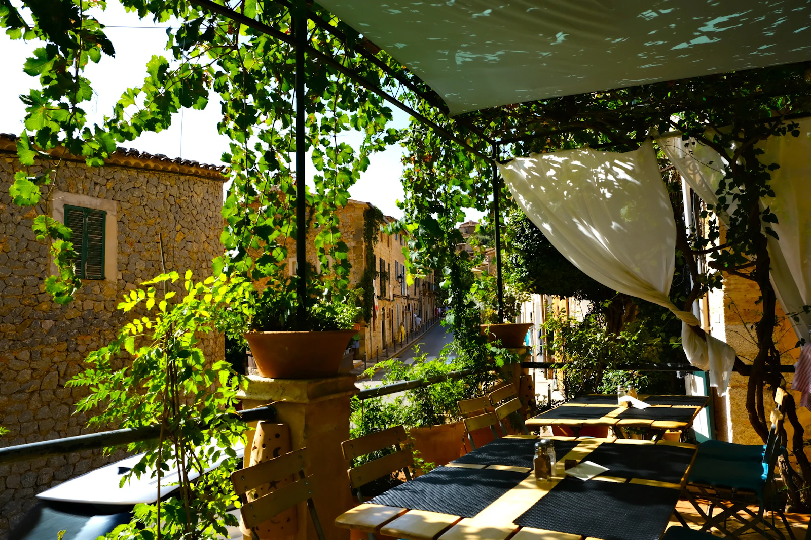 Terrasse ombragée avec tables et chaises sous une pergola